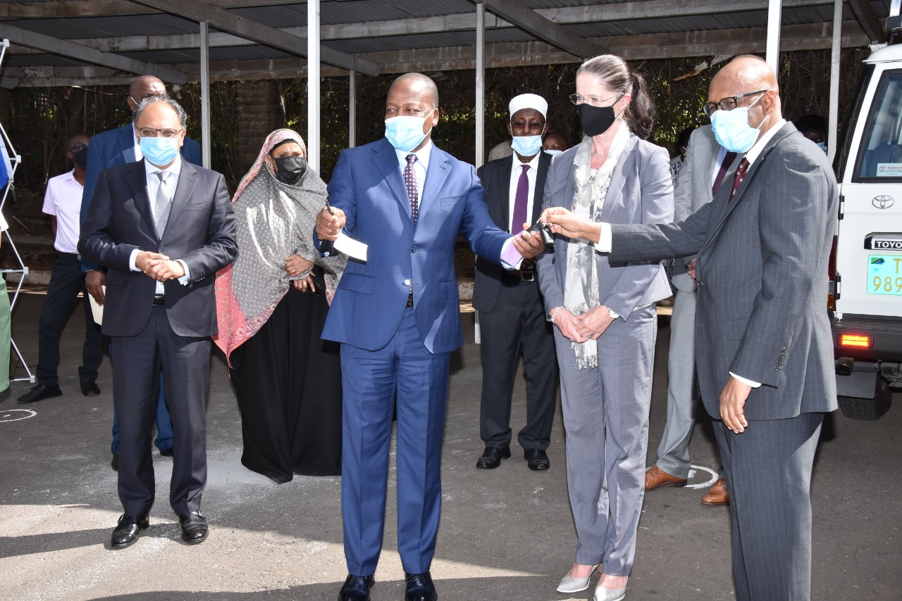 Kenya’s Cabinet Secretary for Health, Hon. Mutahi Kagwe (left), receives car keys for the two EAC Mobile Labs from his EAC Affairs counterpart, Mr. Adan Mohammed. Looking on (centre) is German Ambassador to Kenya, Ms. Annett Gunther.   
