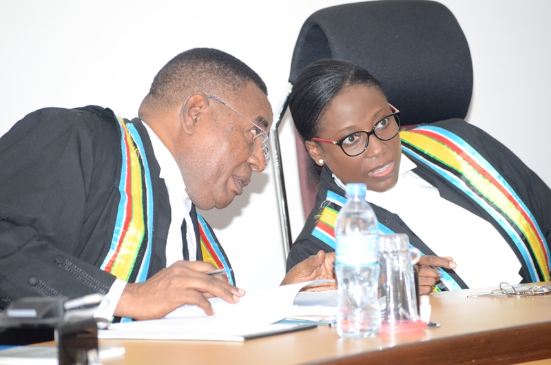 Justice Fakihi Jundu consulting the Principal Judge, Lady Justice Monica Mugenyi in court