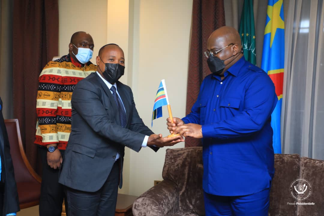  EAC Secretary General Hon. Dr. Peter Mathuki (left) presents the EAC flag to DRC President Felix Tshishekedi to mark the launch of the EAC Verification Mission to the Central African country. On the far left is Prof. Serge Tshibangu, the president's Special Envoy.