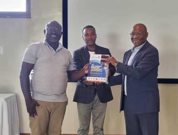 Representative from the Republic of Uganda, Ministry of Energy and Mineral Development, Principal Geologist, Mr. Wilson Tumushabe (l) hands over the EAPCE’23 Conference proceeding among other documents to the Deputy Permanent Secretary, Ministry of Energy Tanzania, Dr. James Mataragio (r). Looking on is EAC Director of Porductive Sectors, Mr. Jean Baptiste Havugimana.