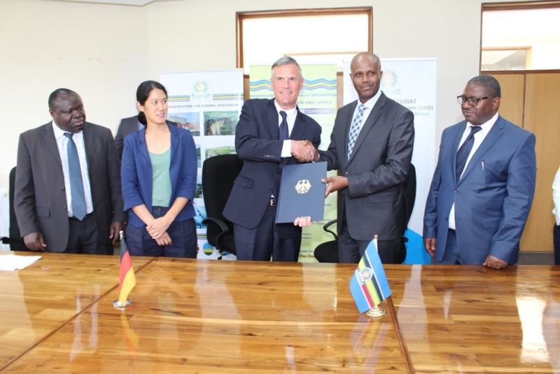  EAC Secretary General Amb. Liberat Mfumukeko exchanges signed copies of the financing agreement with H.E. Dr. Detlef Waechter, Germany’s Ambassador to tanzania and the EAC. Looking on are from left the EAC Deputy Secretary General in charge of Productive and Social Sectors, Hon. Christophe Bazivamo, Ms. Norzin Grigoleit-Dgayab of the German Embassy and the DSG-Planning and Infrastructure, Eng. Steven Mlote.