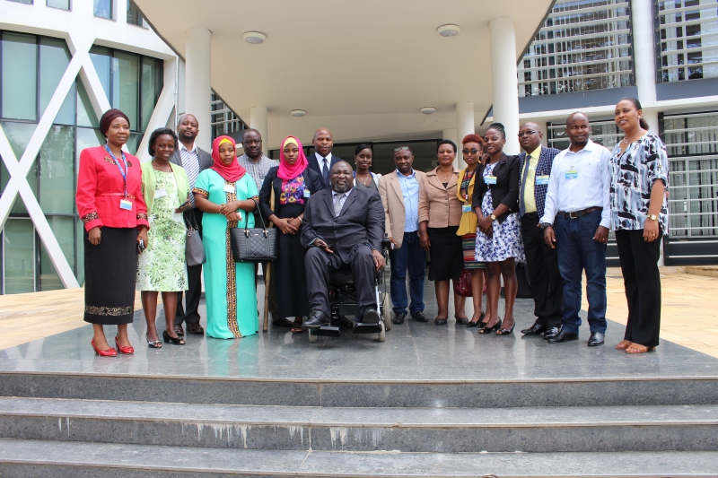 Hon. Alex Ndeezi; AUD President (MP) Uganda, (center) with other members of the AUD and ADA delegation as well as EAC Secretariat and the 50 Million Women Speak Project Staff pose for a group photo outside the EAC Headquarters building.   