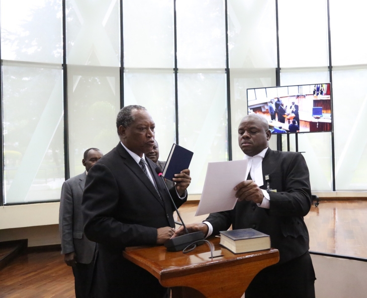 The Minister for Foreign Affairs and East African Co-operation, United Republic of Tanzania, Prof Palamagamba Kabudi takes the oath of Allegiance administered by EALA Clerk Assistant, Victor Manzi.   