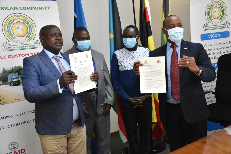 EAC Secretary General Hon. (Dr.) Peter Mathuki (right) and EABC Executive Director John Bosco Kalisa hold aloft the Terms of Reference establishing the Technical Working Group after the signing ceremony at the EAC Headquarters in Arusha, Tanzania. Looking on are the EAC Deputy Secretary General in charge of Planning and Infrastructure, Eng. Steven Mlote (second left) and East African Legislative Assembly Speaker, Rt. Hon. Martin Ngoga